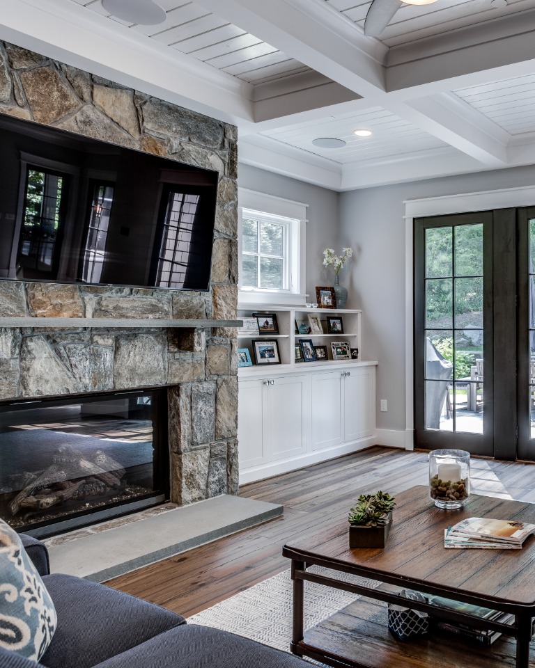 Interior Design in Living Room with Stone Fireplace, Wood Flooring, and Dark Cloth Couch | Tulacro Development | Luxury Custom Home Builders | Bethesda, MD | Montgomery County