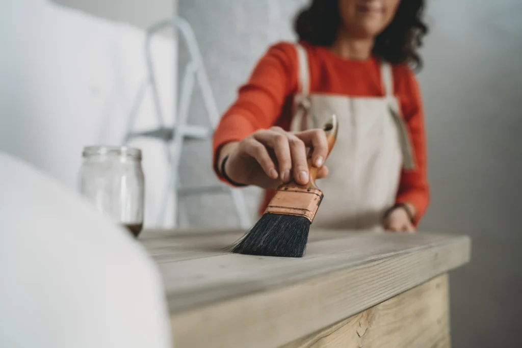 A woman painting a wooden kitchen countertop
