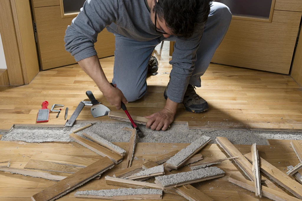 A man fixing wooden uneven flooring